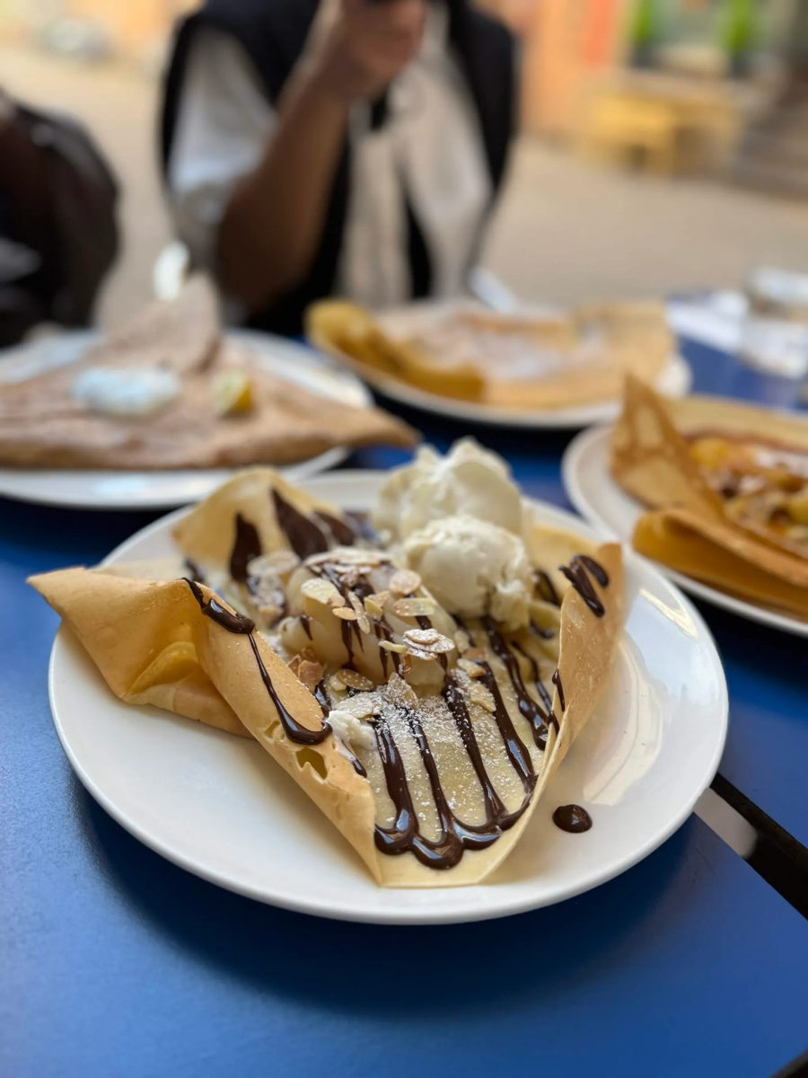 A crepe with chocolate drizzle, sliced almonds and vanilla ice cream at a café in Paris