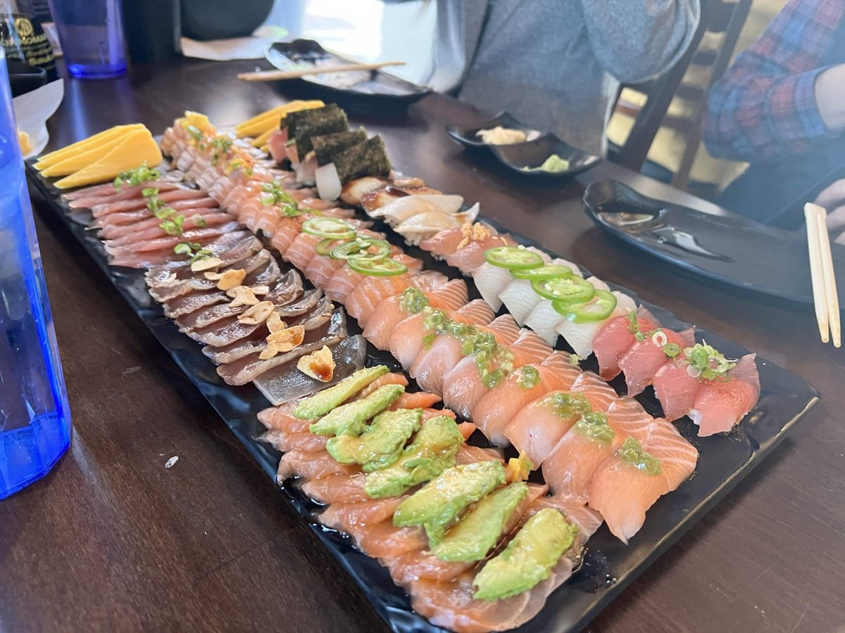 A long platter of salmon, tuna and yellowtail sushi and sashimi