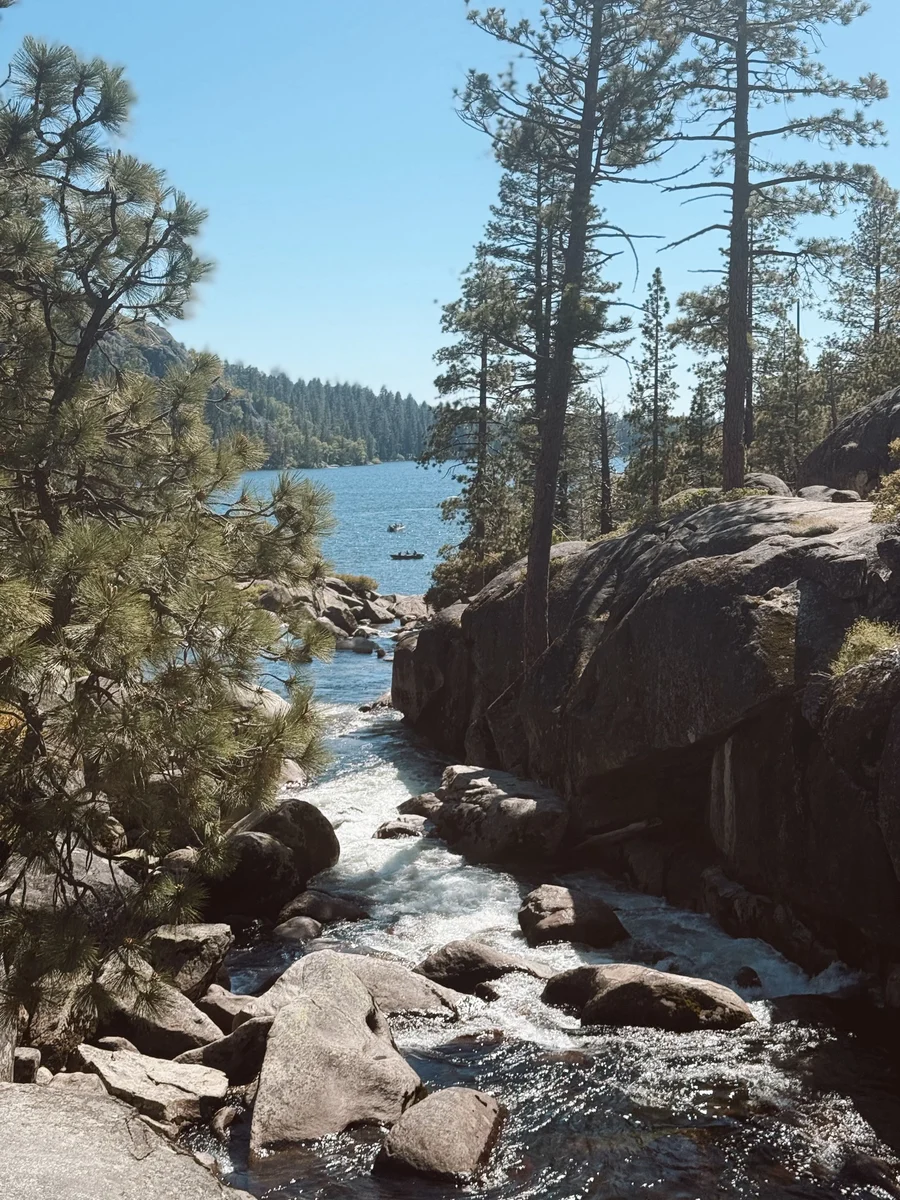 Granite boulders and a rushing creek beside Pinecrest Lake, framed by pine trees