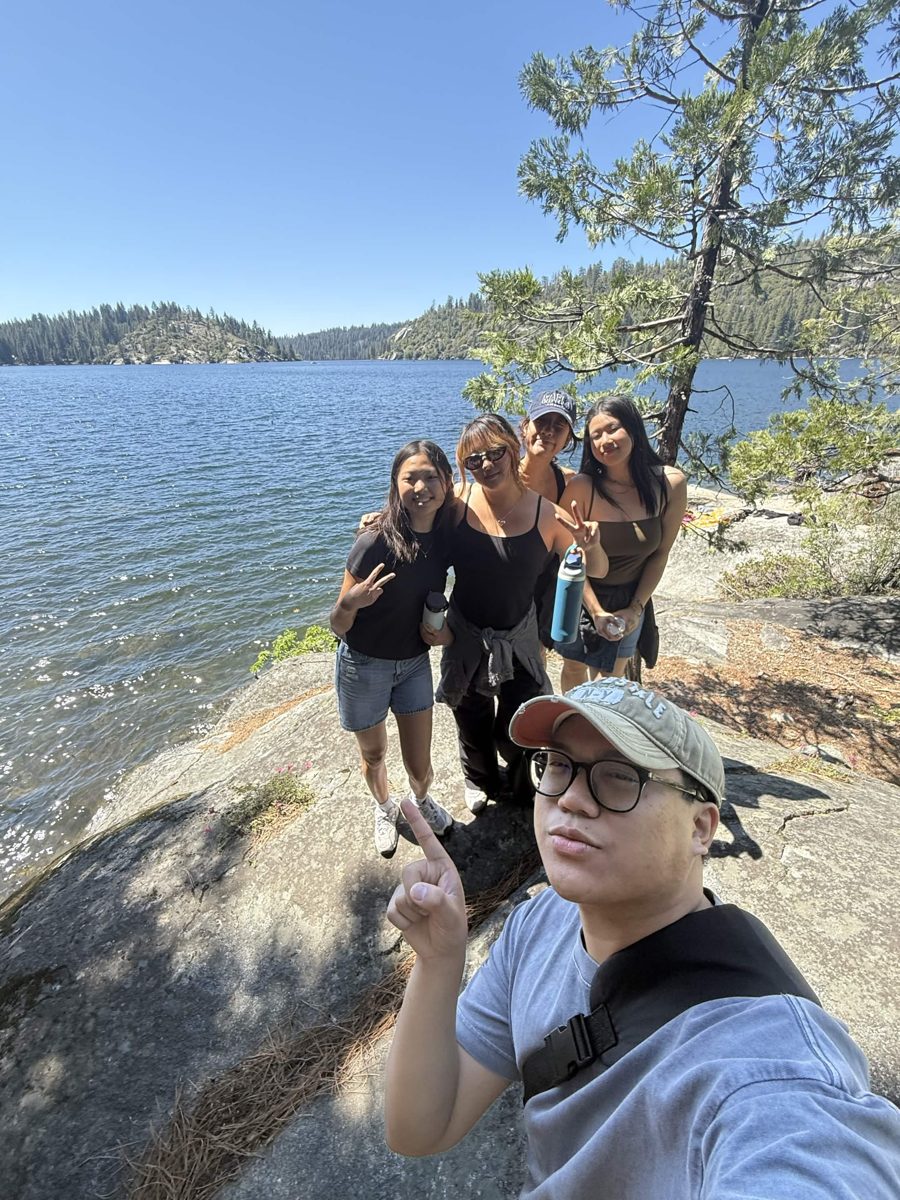 Lyanna and friends on the granite shore of a mountain lake on a hiking trip