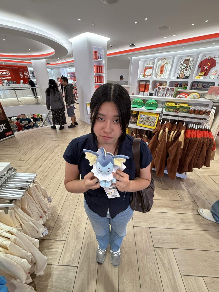 Lyanna holding a Vaporeon plush in a Nintendo store