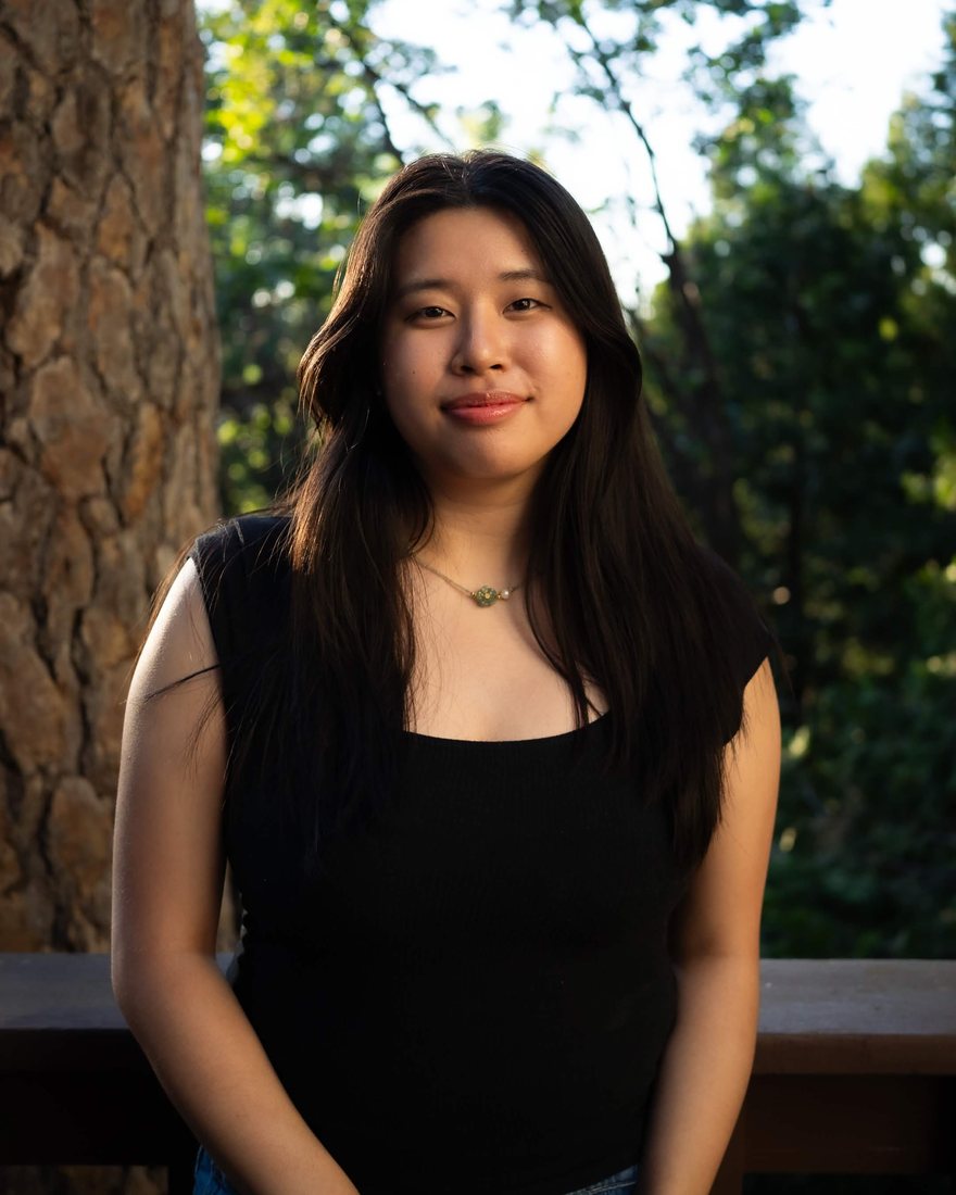 Lyanna Nguyen smiling outdoors among trees